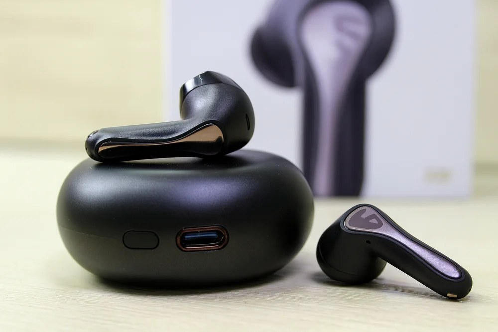 Наушники Soundpeats Air5 Pro крупным планом Беспроводные наушники Soundpeats Air5 Pro и их черный зарядный кейс крупным планом на светлой поверхности